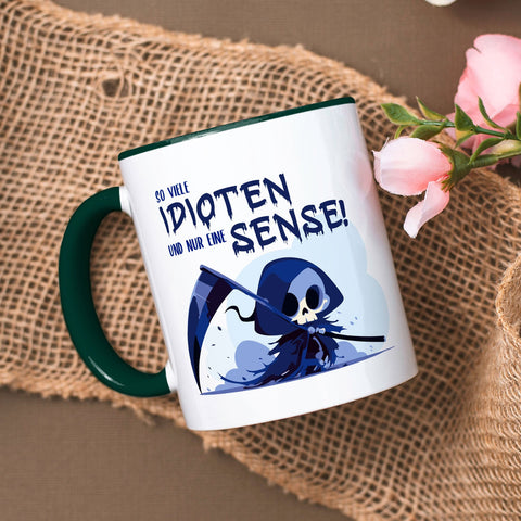 Kubek z nadrukiem i napisem w kolorze niebieskim - Tyle idiotów, a tylko jedna kosa
